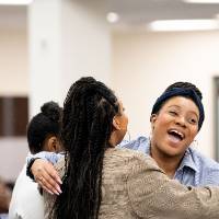 Girls of Color Summit previous event with two girls smiling and hugging